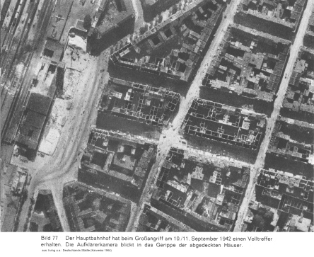Bild 77: Düsseldorfs Hauptbahnhof mit
                        Volltreffer und Häuser daneben ausgebrannt wie
                        offene Schachteln, Kontrollfoto von Mitte
                        September 1942 ca.