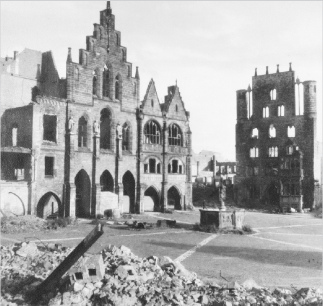 Die Häuser am Marktplatz von Hildesheim sind nur
                noch Ruinen, das Rathaus (links) und das Tempelhaus
                (Templerhaus) (rechts), der Rolandsbrunnen ist
                unversehrt, April 1945 ca.