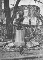 Hildesheim, das Huckup-Denkmal steht
                            vor den Ruinen der Andreaskirche nach dem
                            Feuersturm vom 22. Mrz 1945