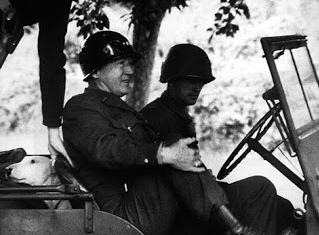 Patton in a jeep with his
                  dog