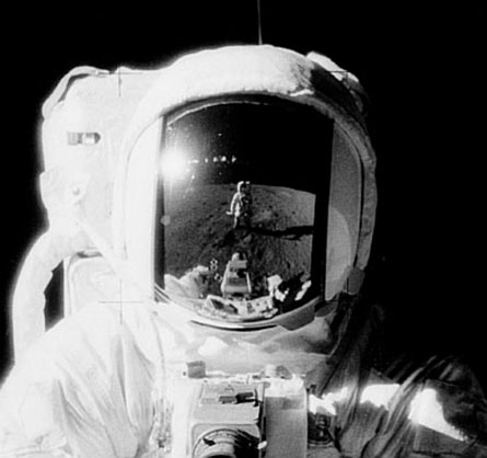 Photo du front de Alan Bean (APOLLO 12, photo
                      no. as12-49-7281, extrait). Dans le casque se
                      miroite pas seulement la persone qui prend la
                      photo, Charles Conrad, mais on a aussi une file
                      des phares du studio de film.