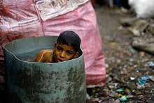 Slum
              Dharavi in Mumbai, ein Bub nimmt in einer Plastiktonne ein
              Bad