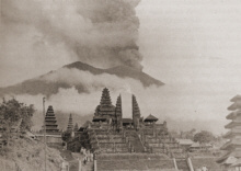 Gunung Agung erupting on
                      Bali, 1963, with Pura Besakih in the foreground.