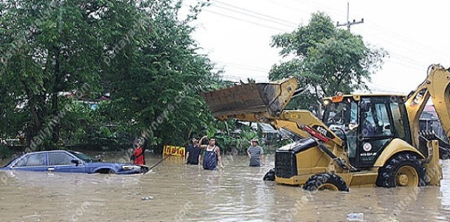 Sattahip (Thailand): Ein Bagger zieht ein
                        Auto aus einer berschwemmung, 31. Oktober 2014