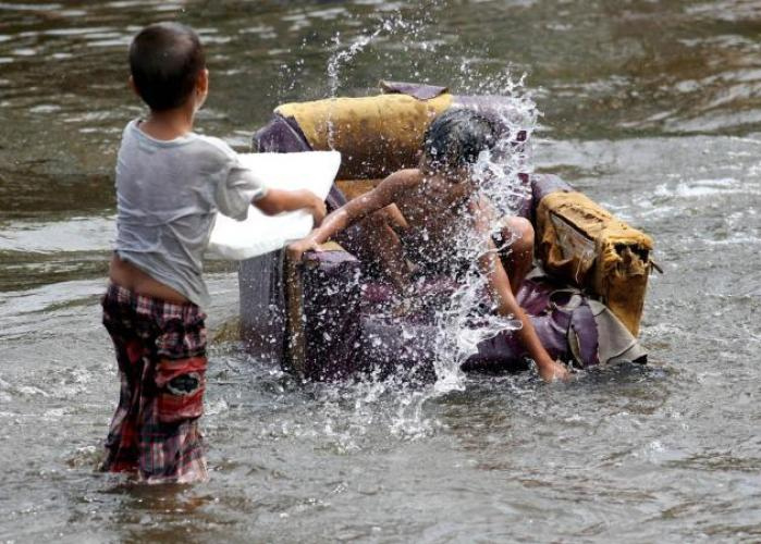 Sdthailand, Kinder im
                  Hochwasser mit einem schwimmenden Sofasessel,
                  27.Dezember 2014