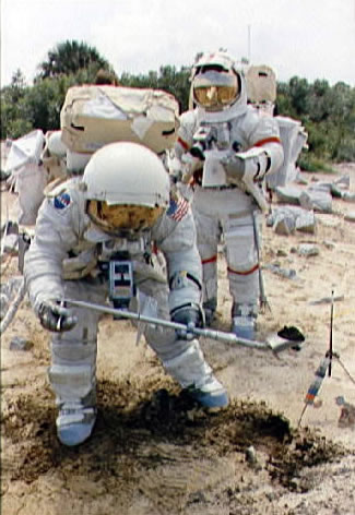 Apolo 17 entrenamiento:
                        astronautas en un superficie lunar simulado
                        toman muestras de la tierra