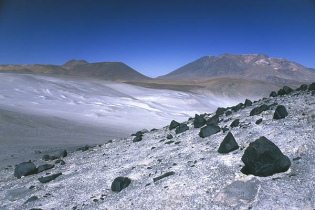 Desierto de Atacama (16) cerca de
                                  Salar de Aguas Calientes: pendientes
                                  con capa blanca de sal, y cordilleras
                                  al fondo [21]