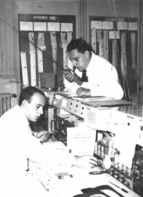 The
                            Judica-Cordiglia brothers in their
                            monitoring station "Torre Bert"
                            near Turin, Gian Battista Judica-Cordiglia
                            right. In the background orbit protocols of
                            "American" and "Soviet"
                            satellites can be seen.