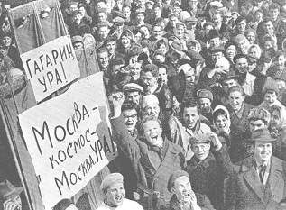 Gagarin: "Le Chemin" (12): Die
                        Menschenmenge auf dem Roten Platz zeigt
                        Transparente, die Moskau in den Kosmos jubeln.