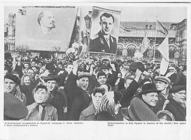 Gagarin-Faltprospekt (13), Feier
                                auf dem Roten Platz mit Plakaten von
                                Fallschirmspringer Gagarin neben dem
                                Kommunisten und Massenmörder Lenin