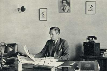 Walt Disney at his desktop
                        in 1932. He surveys drawings of a
                        "Mickey".