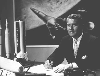 Wernher von Braun in seinem Bro
                          (16.9.1960) mit einer Science-Fiction-Malerei
                          im Hintergrund mit irrealer eindsiger
                          Landefhre.