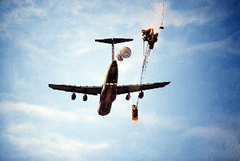 Fallschirmabwurf eines Panzers aus
                        einer Herkules C-5, die Fallschirme sind noch
                        zu