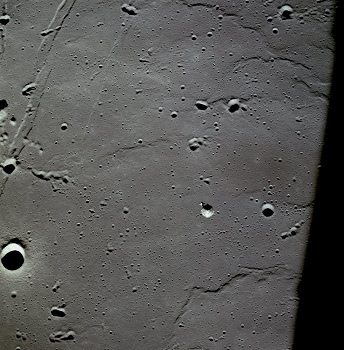 Apollo 11, Foto Nr. AS11-37-5447: Die NASA
                        behauptet, dies sei die Kommandokapsel über dem
                        "Meer der Stille". Die NASA behauptet,
                        der Landeplatz von Apollo 11 sei im Zentrum des
                        Fotos, oben links befinde sich der Moltke-Krater
                        und die Hypatia-Rille, rechts ein Krater
                        "Collins", der Krater
                        "Aldrin" ("Amboss") soll
                        sich oben rechts befinden, und die Krater Sabine
                        E, D und B werden später nach den
                        "Astronauten" Armstrong, Aldrin und
                        Collins benannt.