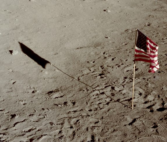 Apollo 11 photo no. AS11-37-5466: foot
                          prints, unrealistic flag and unrealistic
                          shadow of the flag in a close-up.