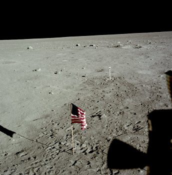 Apollo 11 Foto-Nr. AS11-37-5480: Die NASA
                        behauptet, dies sei ein Foto durch das Fenster
                        von "Astronaut" Edwin
                        ("Buzz") Aldrin, mit der
                        "amerikanischen" Flagge und mit der
                        Kamera "auf dem Mond". Zum ersten mal
                        erwähnt die NASA nun auch das Kamerakabel.