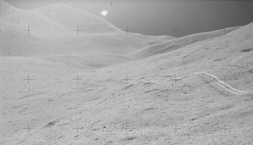 Faked moon landing Apollo 15 photo no.
                AS15-90-12191: Impossible wheel tracks with broad white
                lines - oval Sun - and haze