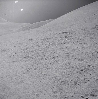 Faked moon landing Apollo 15 photo no.
                        AS15-90-12213: Impossible wheel tracks like a
                        snowplow, two Suns and haze.