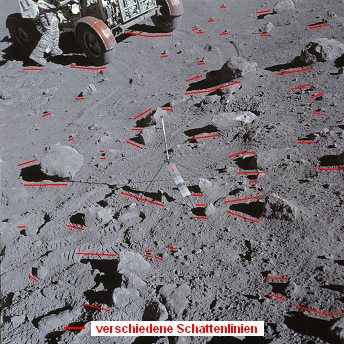 Apollo 16 Foto-Nr. AS16-106-17445:
                        Astronaut Young mit "Mondauto" in
                        einer steinigen Landschaft, Schattenchaos erstes
                        Foto