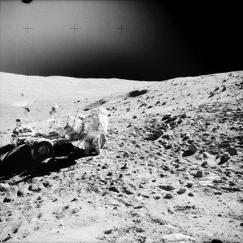 Apollo 16 Foto-Nr. AS16-110-17961:
                        "Mondauto" im Vordergrund in der
                        Steinwste an einem Abhang mit Astronaut Young,
                        der "North-Ray-Krater" im Hintergrund
                        - - und da ist Dunst und ein dunkles,
                        undefinierbares Objekt am oberen Bildrand