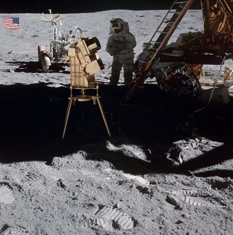 Apollo 16 Foto-Nr. AS16-110-18439:
                        Testapparatur im Schatten der
                        "Mondlandefhre" (Lunar Module LM) mit
                        "Mondauto" und Fahne ohne Schatten.