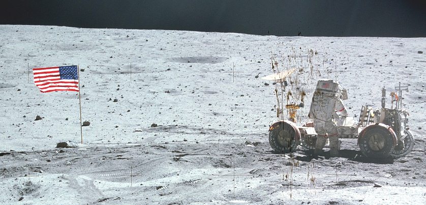 Apollo 16 Foto-Nr. AS16-116-18576:
                          Astronaut Young beim
                          Rover-"Mondmobil" (LRV): Links eine
                          Fahne mit dem Schatten von links nach rechts,
                          rechts der Astronaut mit dem
                          "Mondfahrzeug" mit dem Schatten von
                          rechts nach links. Nahaufnahme. Die
                          Lichtverhltnisse wurden korrigiert.