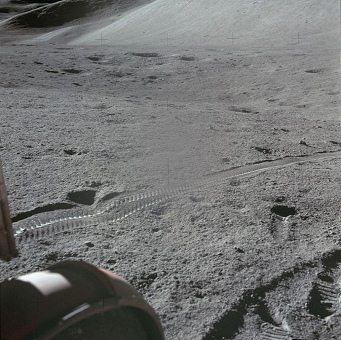 Mondlandung Apollo 15 Foto-Nr.
                        AS15-86-11587: Sicht über das linke Hinterrad
                        auf die Reifenspur der rechten Räder.