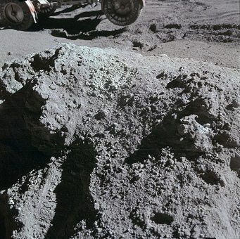 Mondlandung Apollo 15 Foto-Nr.
                        AS15-86-11660: Das "Mondauto" steht
                        immer noch am Hang mit dem Heck in der Luft,
                        Scott hat sein Werkzeug in die Hand genommen,
                        der Stein liegt leer da.