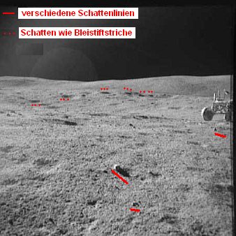 Apollo 16 Foto-Nr. AS16-109-17787: Station
                        1, das "Mondauto" in der Steinwüste,
                        Schattenchaos, und da sind Schatten, die wie
                        Bleistiftstriche aussehen, die da ins Foto
                        hineingezeichnet sind