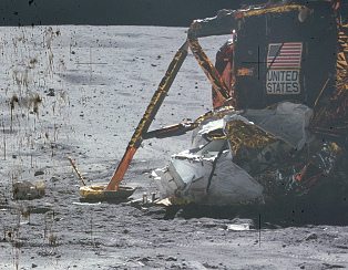 Apollo 16, Foto Nr.
                                    AS16-116-18577: Da liegt Müll neben
                                    der "Mondlandefähre", und
                                    die Werbetafel "United
                                    States" ist zum teil
                                    durchgestrichen, und es scheint so,
                                    dass der Schatten des sichtbaren
                                    Landefusses der
                                    "Mondlandefähre" fehlt.