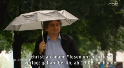 Christian
                Adam beim Spaziergang im Regen mit Regenschirm