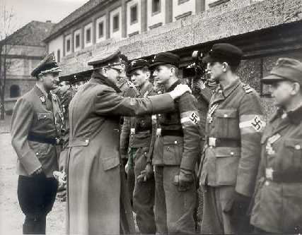 Hitler am
              20.3.1945, Auszeichnung von Volkssturmkämpfern mit dem
              Eisernen Kreuz, mit klarem Buckel, und die linke Hand
              sieht man nicht.