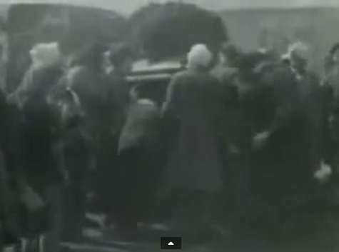 Such
                            people are NOT Jewish detainees but GERMAN
                            soldiers in gray coats and with head
                            injuries with white head bandages. Here they
                            are standing allegedly around a "water
                            lorry". (2min. 9sec.)