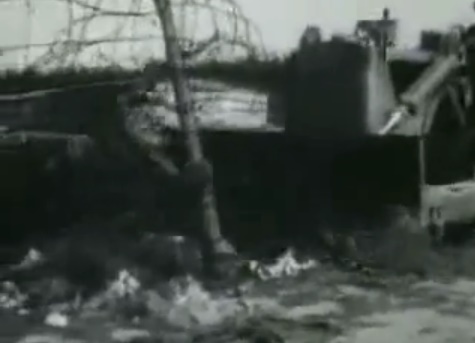 A bulldozer flattening Bergen Belsen camp
                        cutting the barbed wire fence (27min. 58sec.)