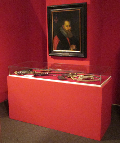 Vitrine mit Waffen und einem Gemlde mit Johann
                Bolandt