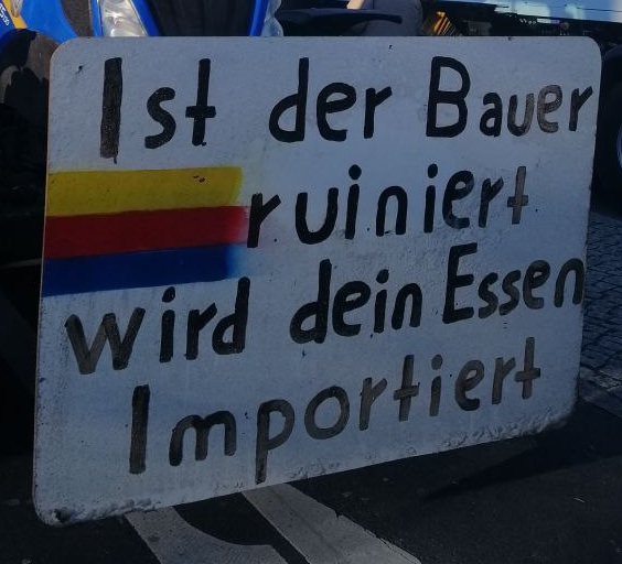 Demo der Bauern am 8.1.2024:
                    Plakat: "Ist der Bauer ruiniert, wird dein
                    Essen importiert"