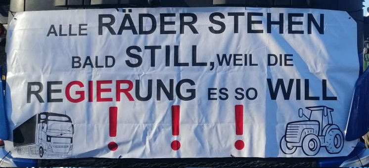 Demo der Bauern am 8.1.2024: Plakat: Alle
                    Rder stehn bald still, weil die Regierung es so
                    will