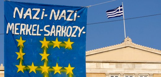 Griechenland, Demonstration mit
                einem Transparent gegen Merkel und Sarkozy als Nazis und
                einer EU-Fahne mit den EU-Sternen als Hakenkreuz