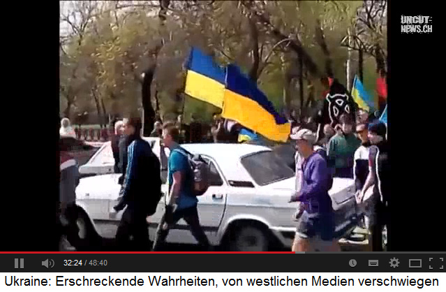 Demonstration in
                    Berdjansk mit einem Transparent mit einem
                    rechtsradikalen Kreuz