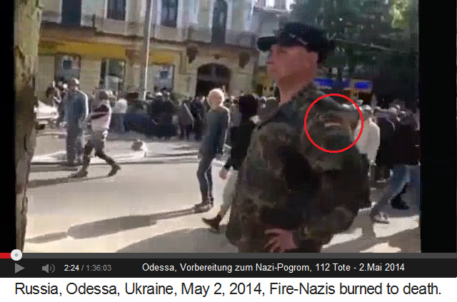 Ein verkleideter, ukrainischer Nazi in
                    Armeeuniform mit einer russischen Flagge drauf