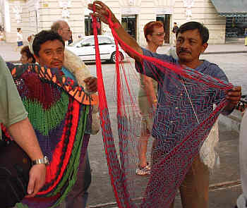 Maya street merchant
                              presenting textiles