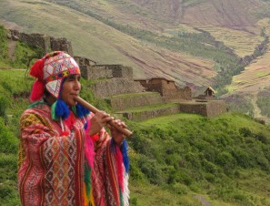 Inca
                            flute player with ruins of Pisac in the back
                            ground