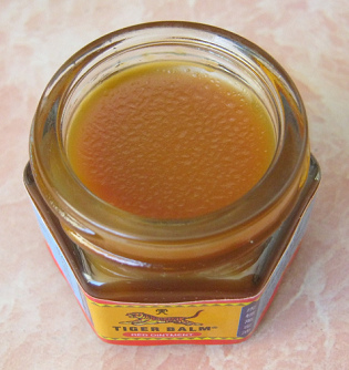 Glass of tiger
              balm without tap showing the red tiger balm