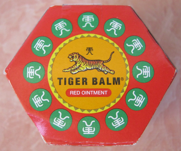Der
                      Schachteldeckel des Tigerbalsam mit dem runden
                      Logo mit dem orangen Tiger