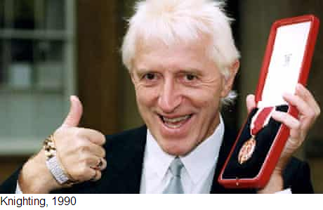 Der
                          kriminell-pädophile Täter bekommt 1990 den
                          Ritterschlag mit Medaille
                          ("Knighting", 1990)